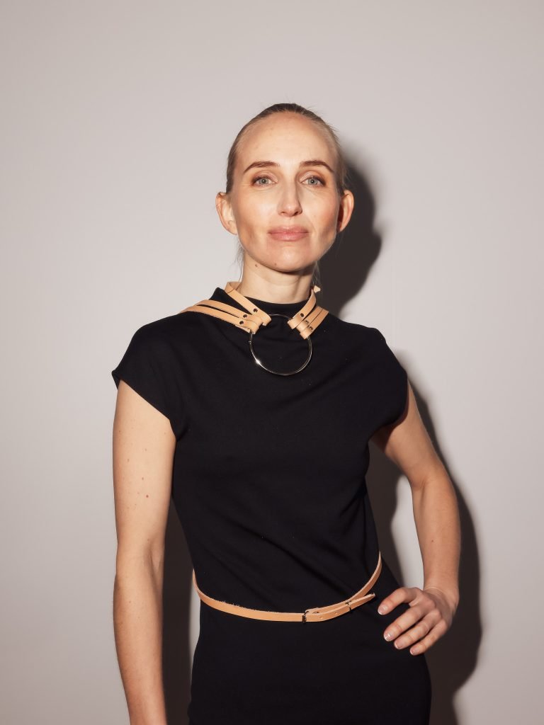 a woman in a black dress with a we got cookies fashion harness