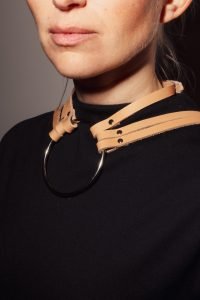 a woman in a black dress with a we got cookies fashion harness