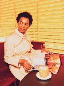 a woman sitting in a chair reading a magazine with a we got cookies harness